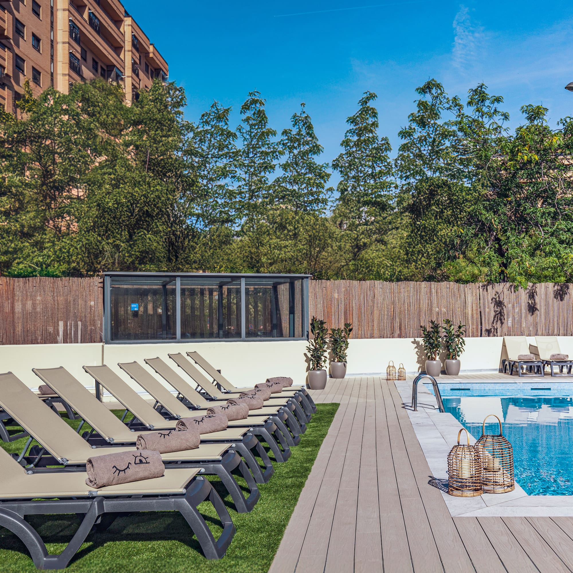 a pool with lounge chairs and a wood deck