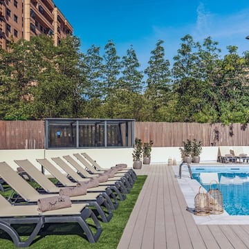 a pool with lounge chairs and a wood deck