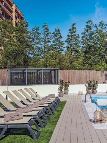 a pool with lounge chairs and a wood deck