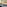 Modern hotel room with large bed, wooden headboard, art, and seating area.