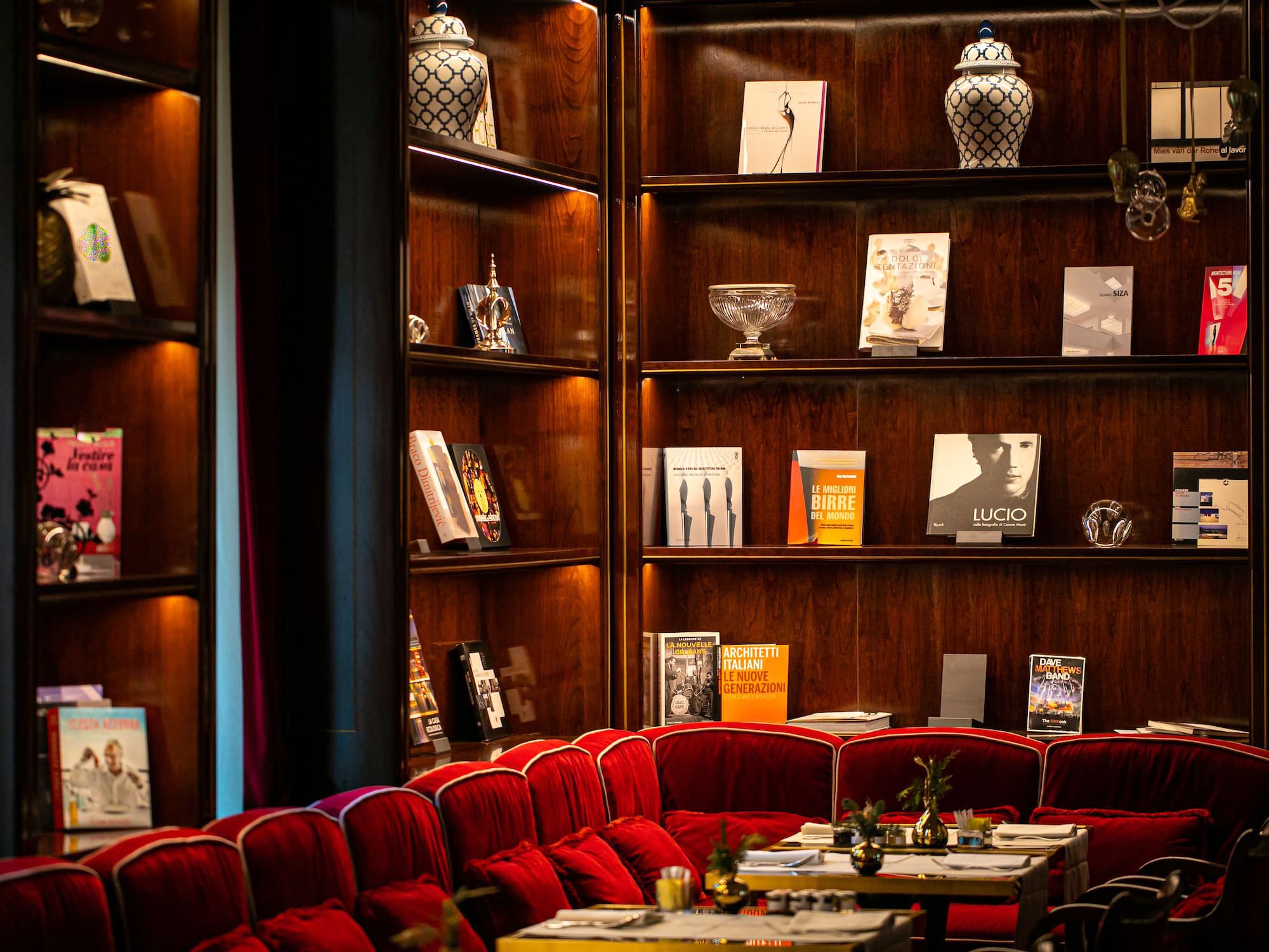 a room with red chairs and tables and books on shelves