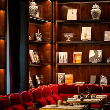 a room with red chairs and tables and books on shelves