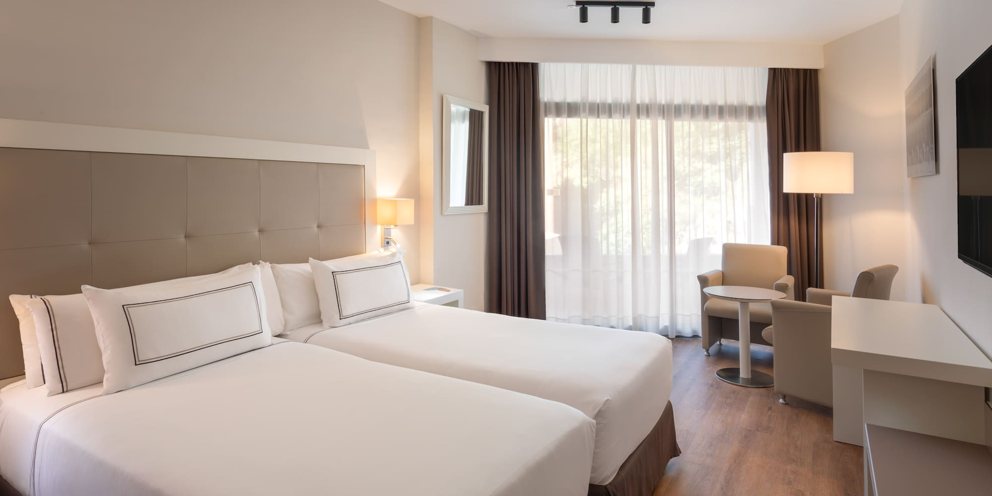 a room with two beds and a table and chairs