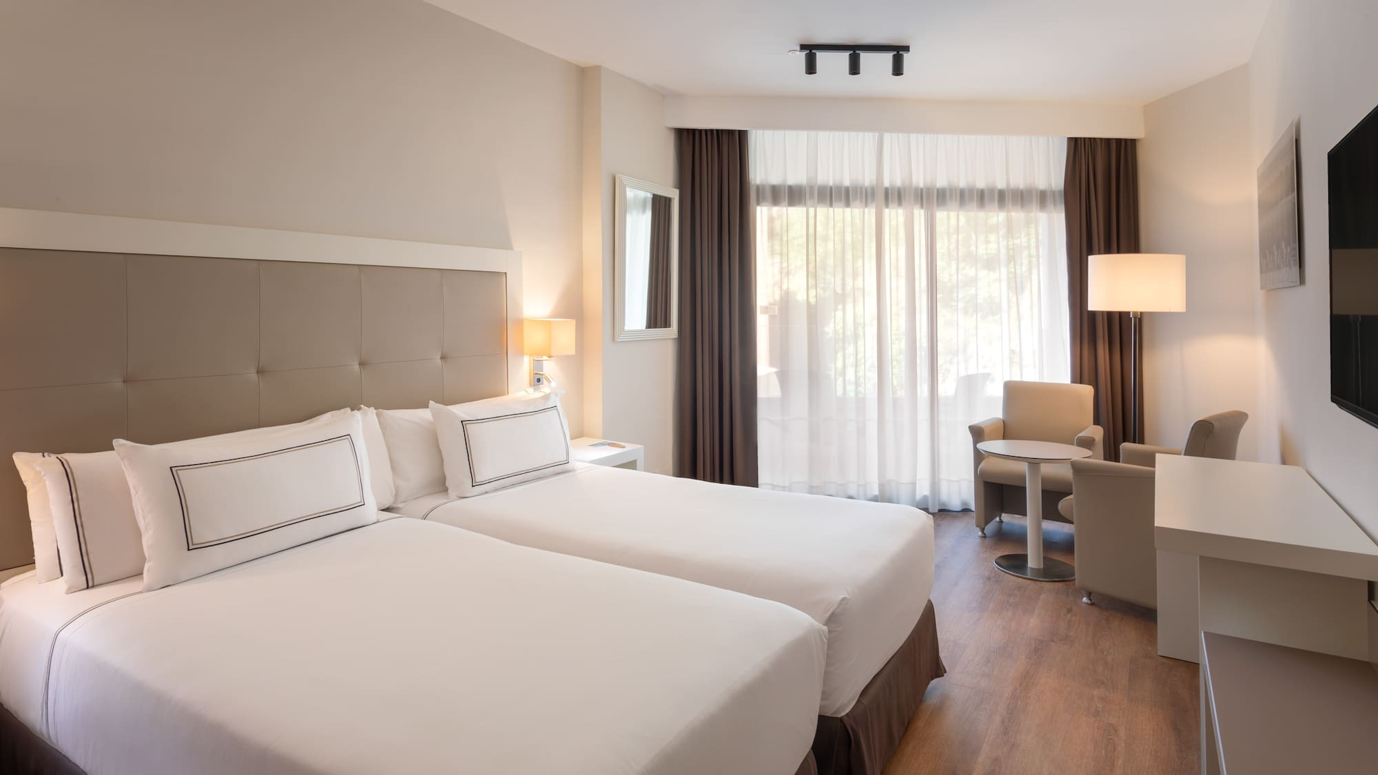 a room with two beds and a table and chairs