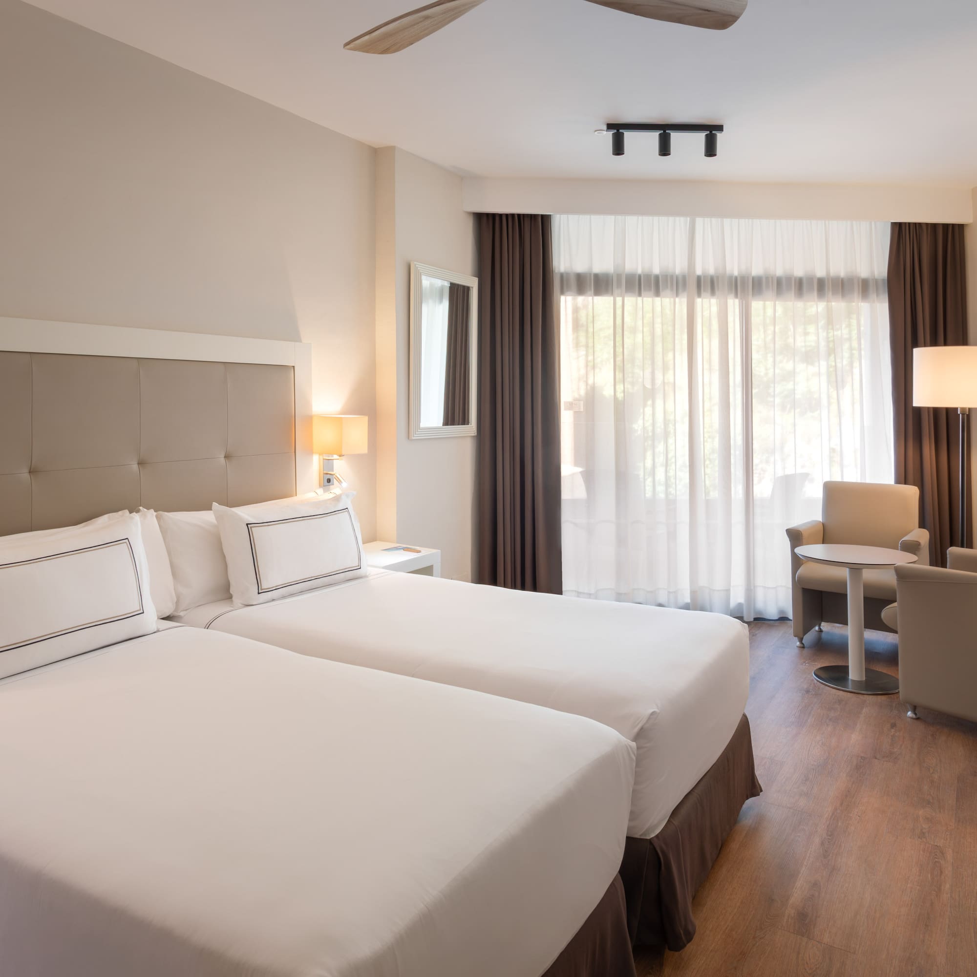 a room with two beds and a table and chairs