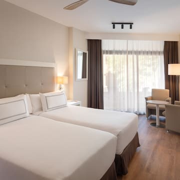 a room with two beds and a table and chairs