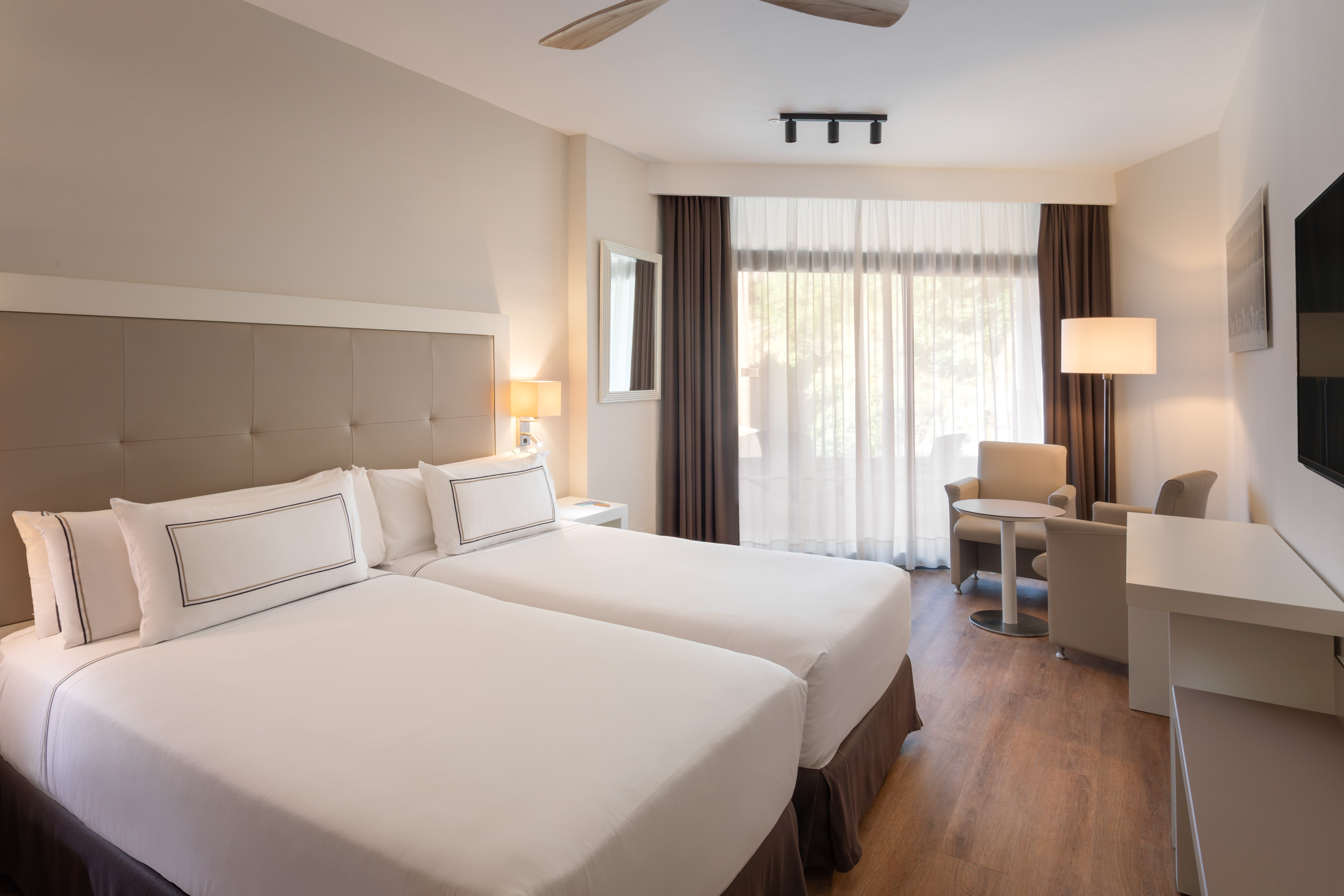 a room with two beds and a table and chairs