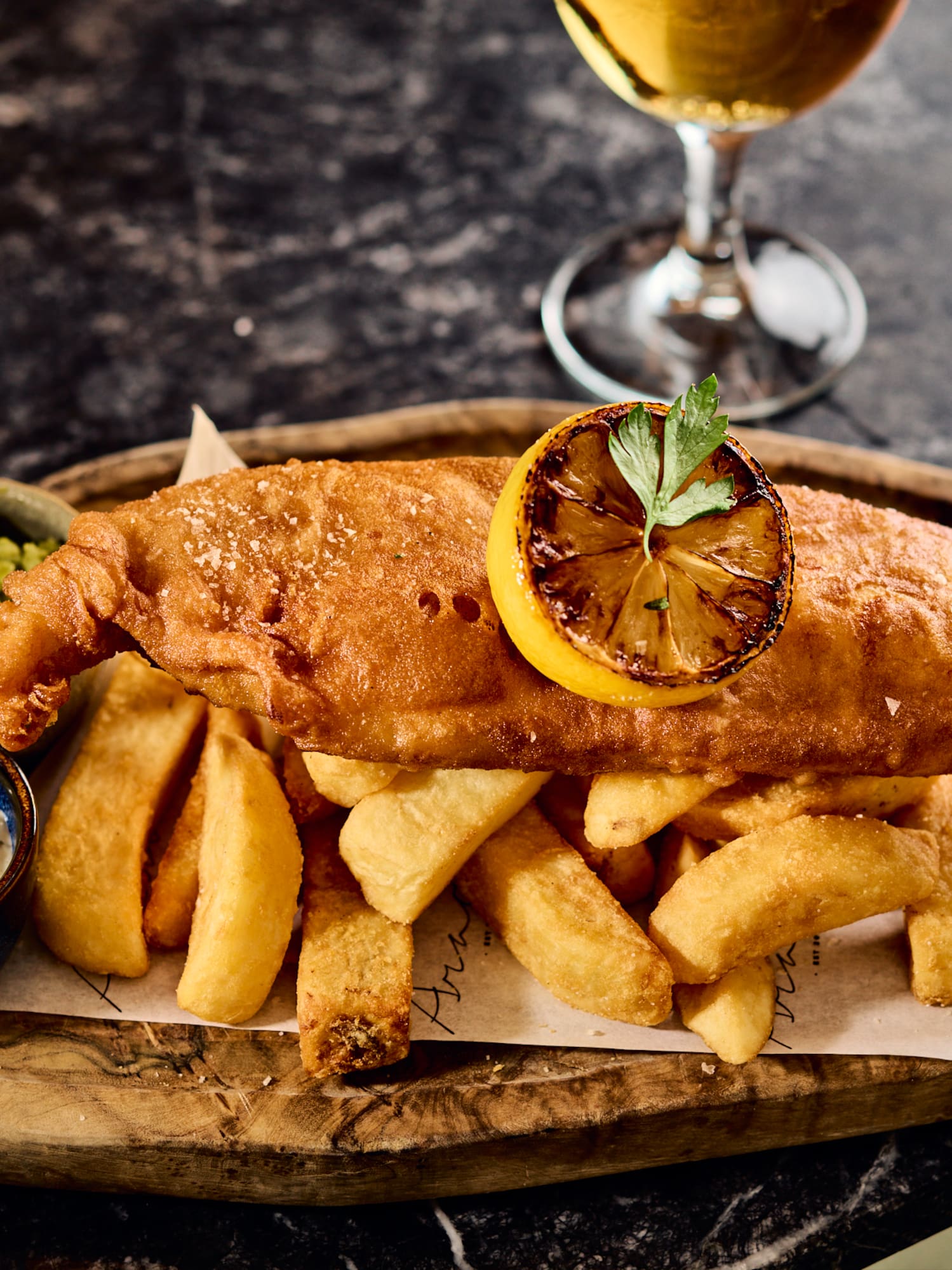 a plate of food with sauces and a glass of beer