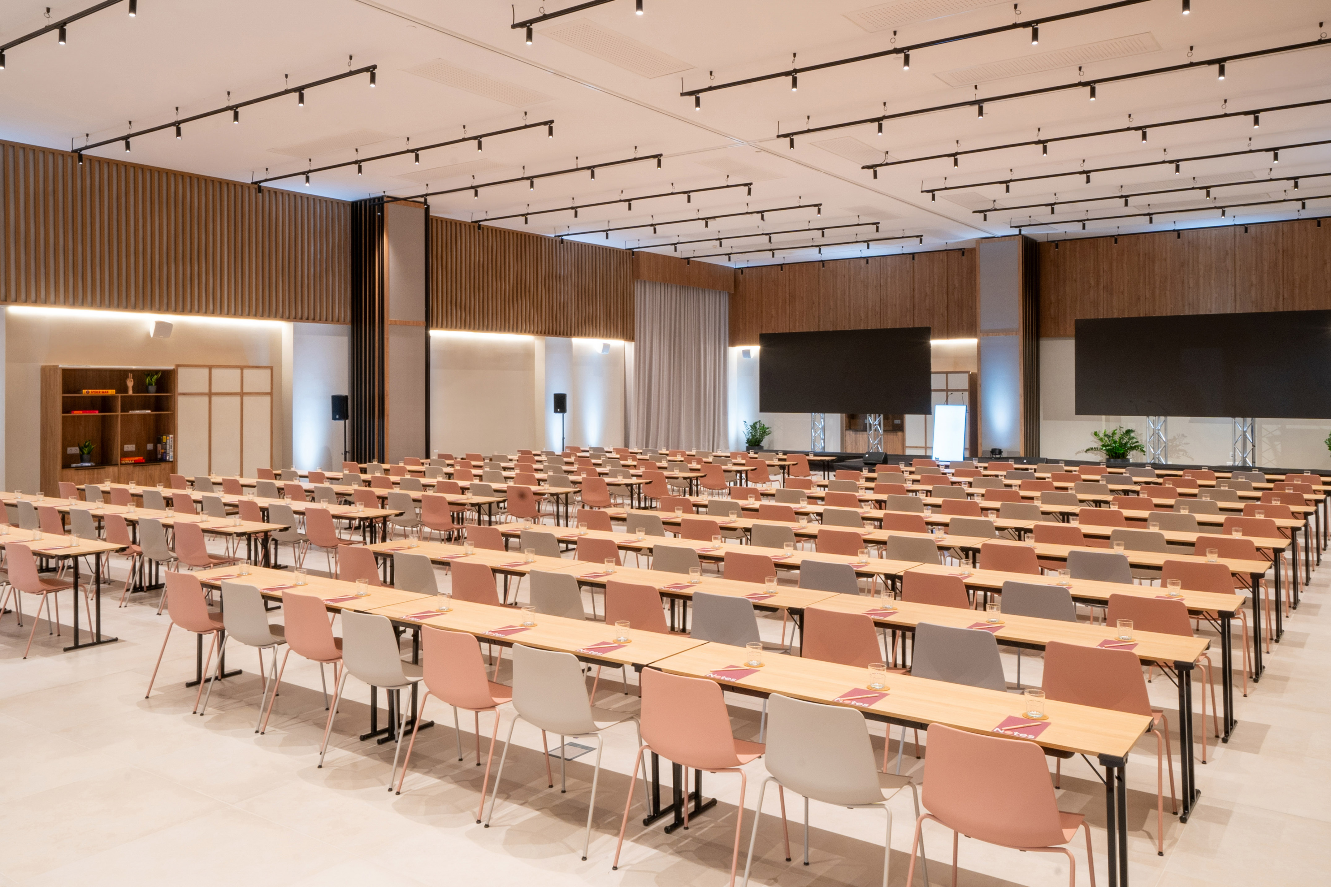 Modern black track lighting on white acoustic ceiling with wood wall panels.