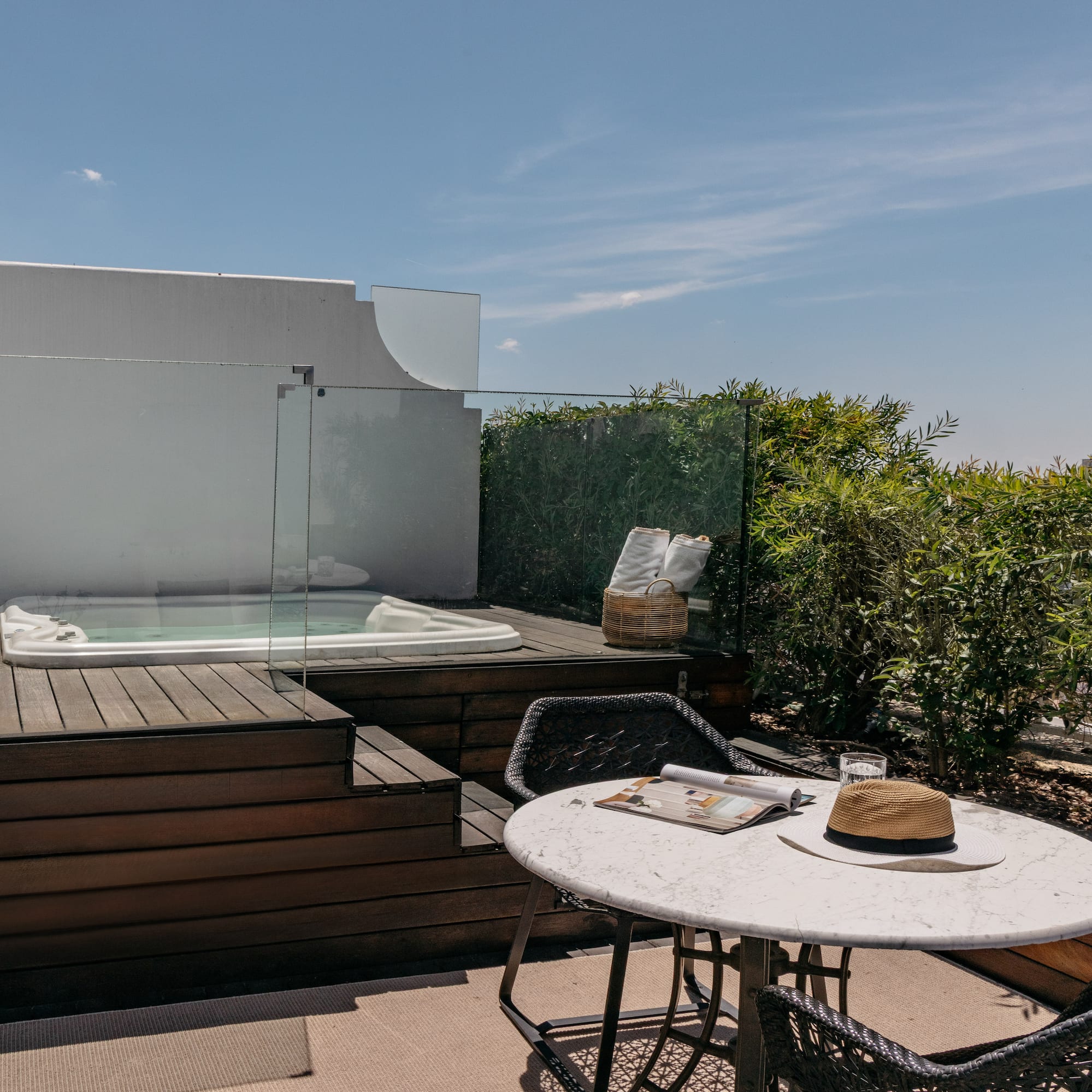 a table and chairs on a deck with a hot tub