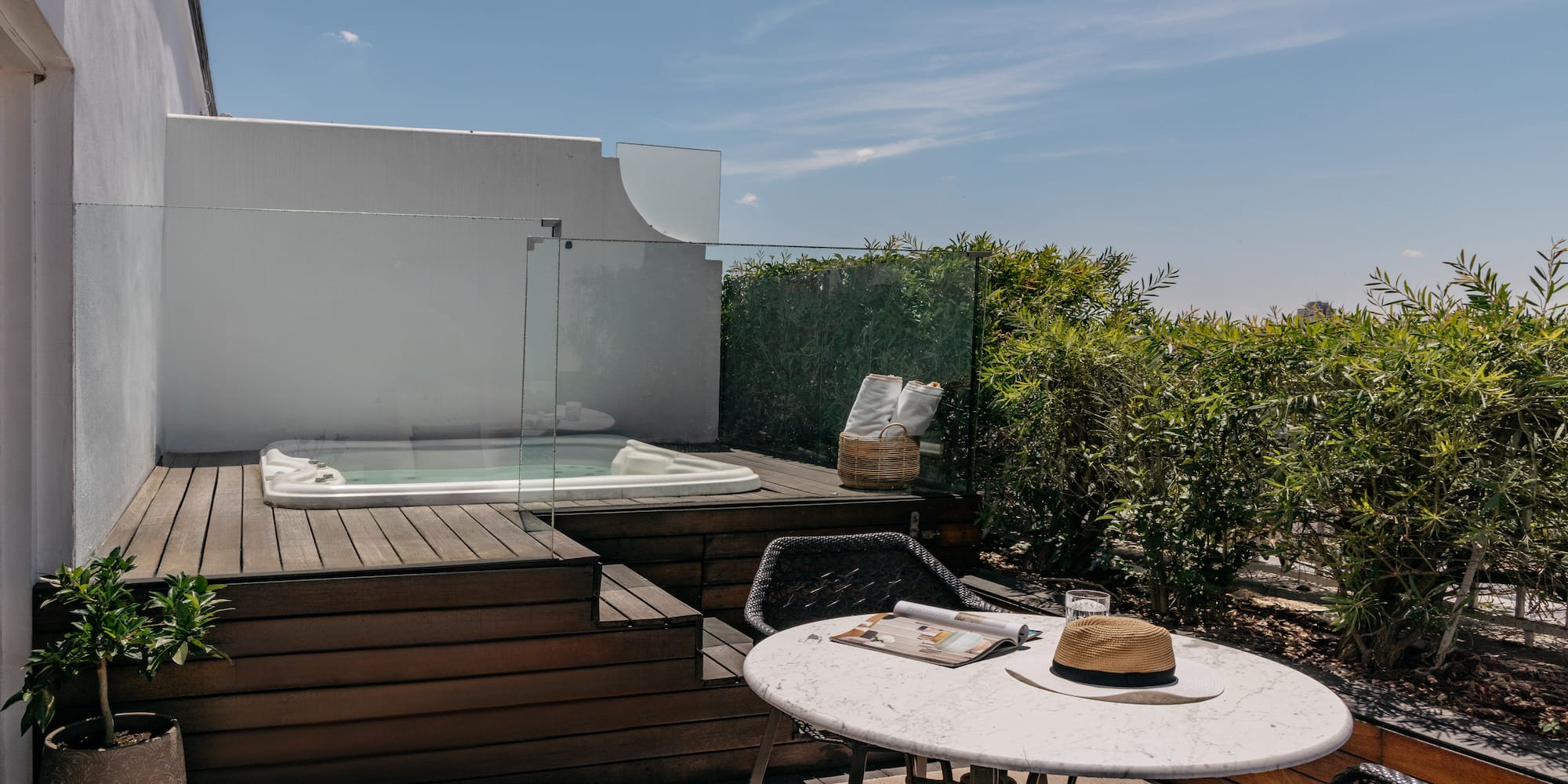 a table and chairs on a deck with a hot tub