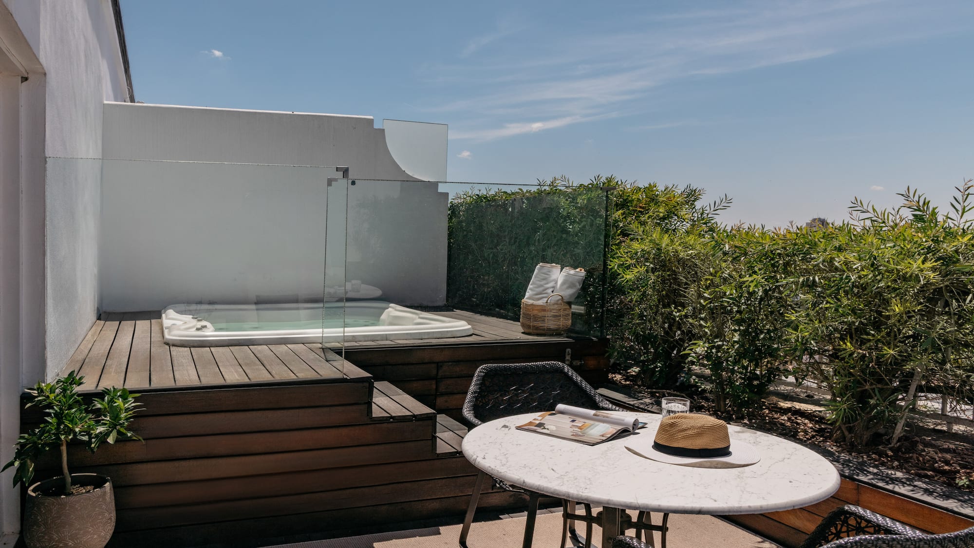 a table and chairs on a deck with a hot tub