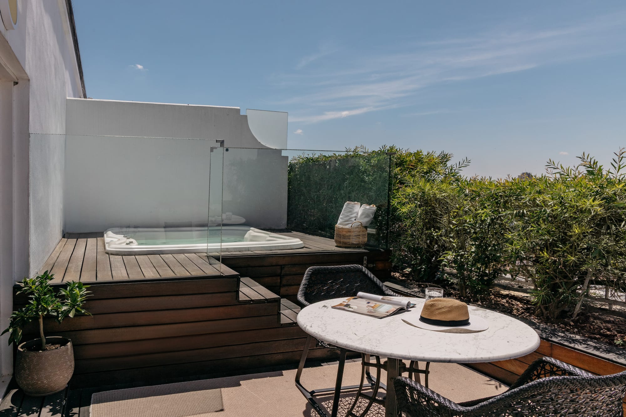 a table and chairs on a deck with a hot tub