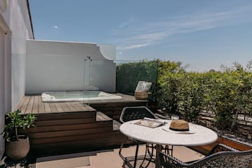 a table and chairs on a deck with a hot tub