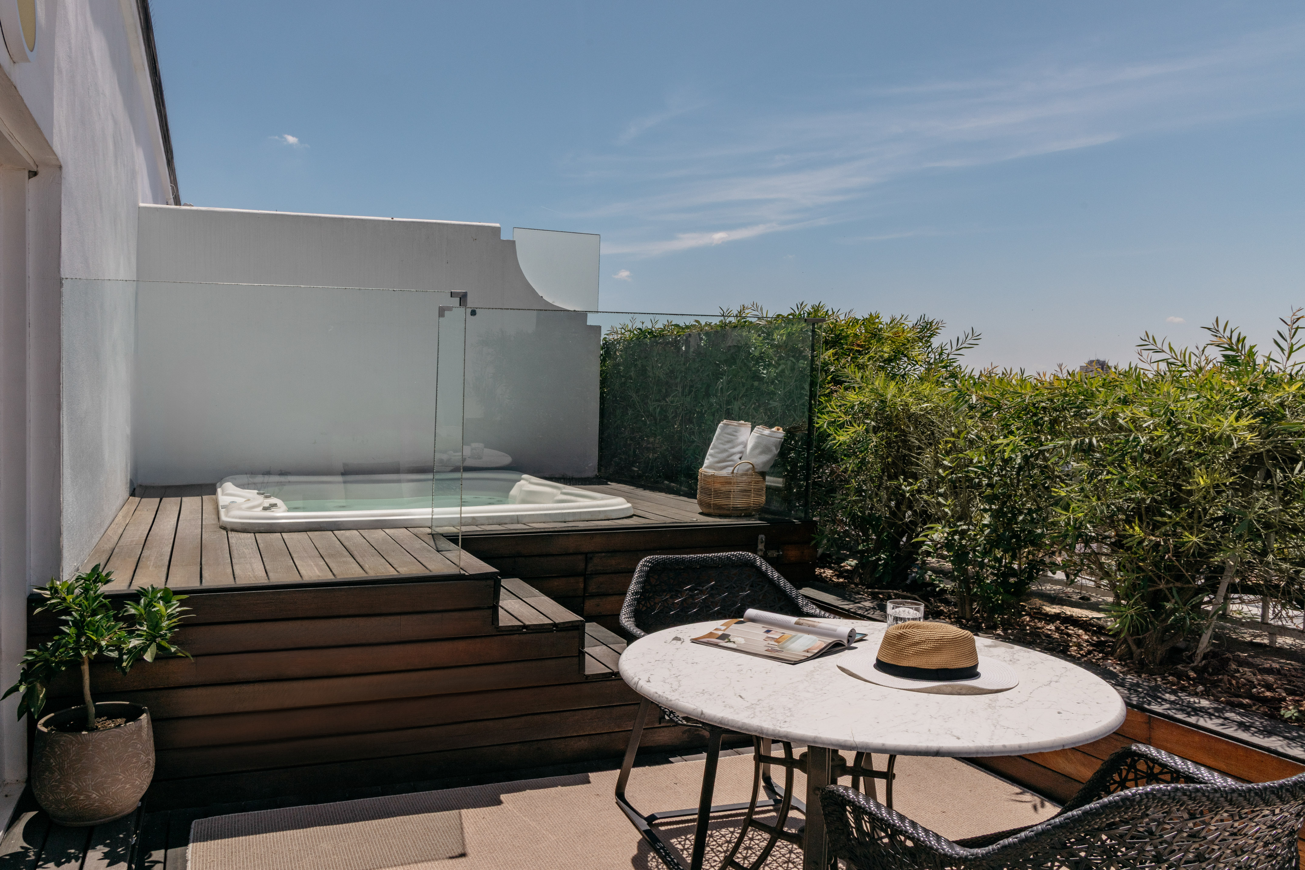 a table and chairs on a deck with a hot tub