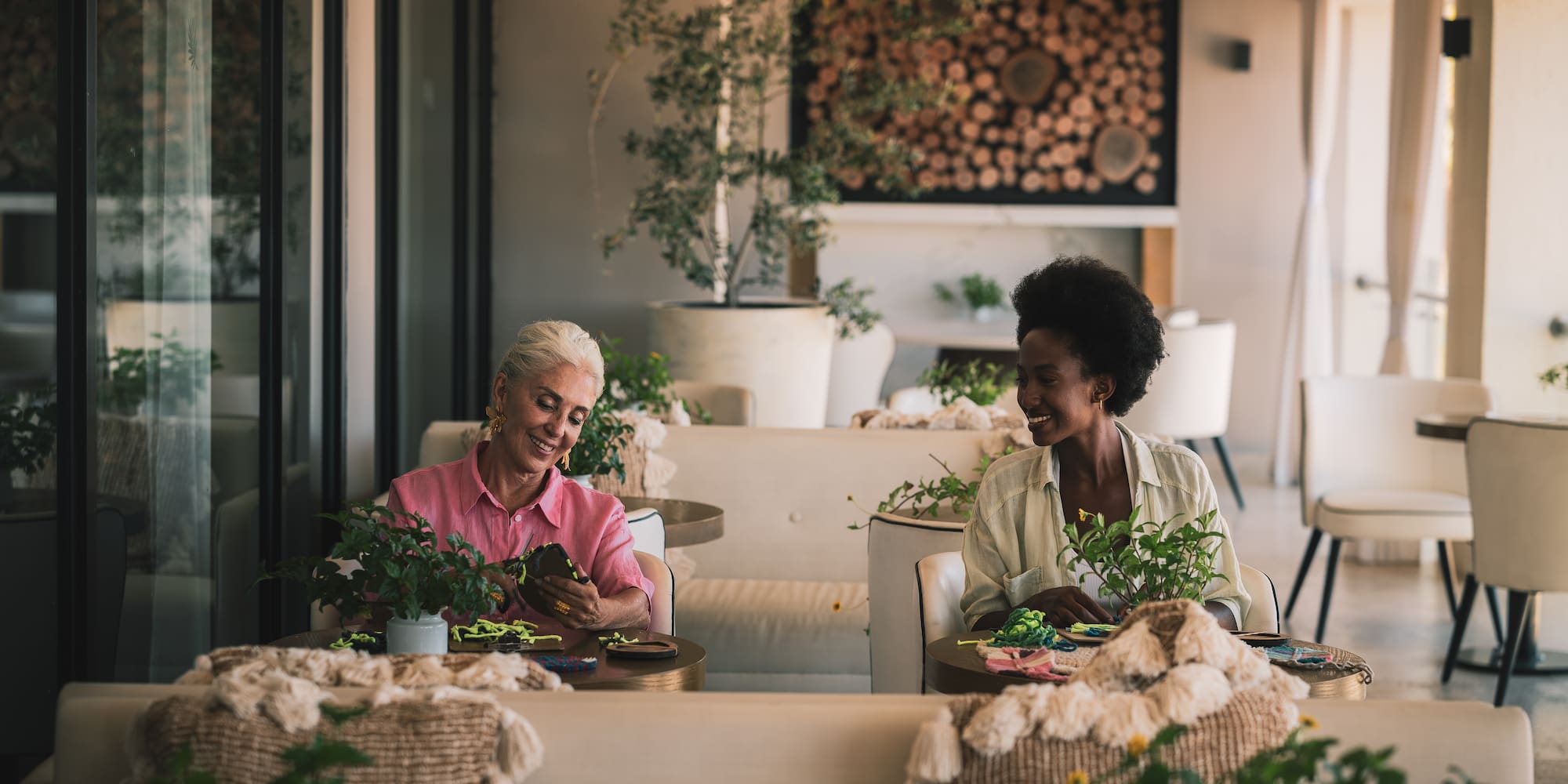 two women sitting at tables in a restaurant