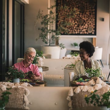 two women sitting at tables in a restaurant