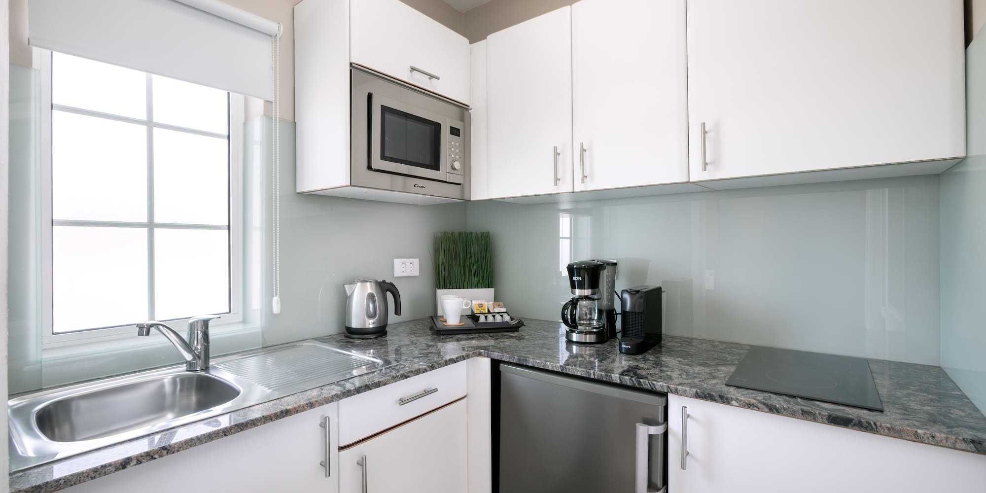 a kitchen with white cabinets and appliances