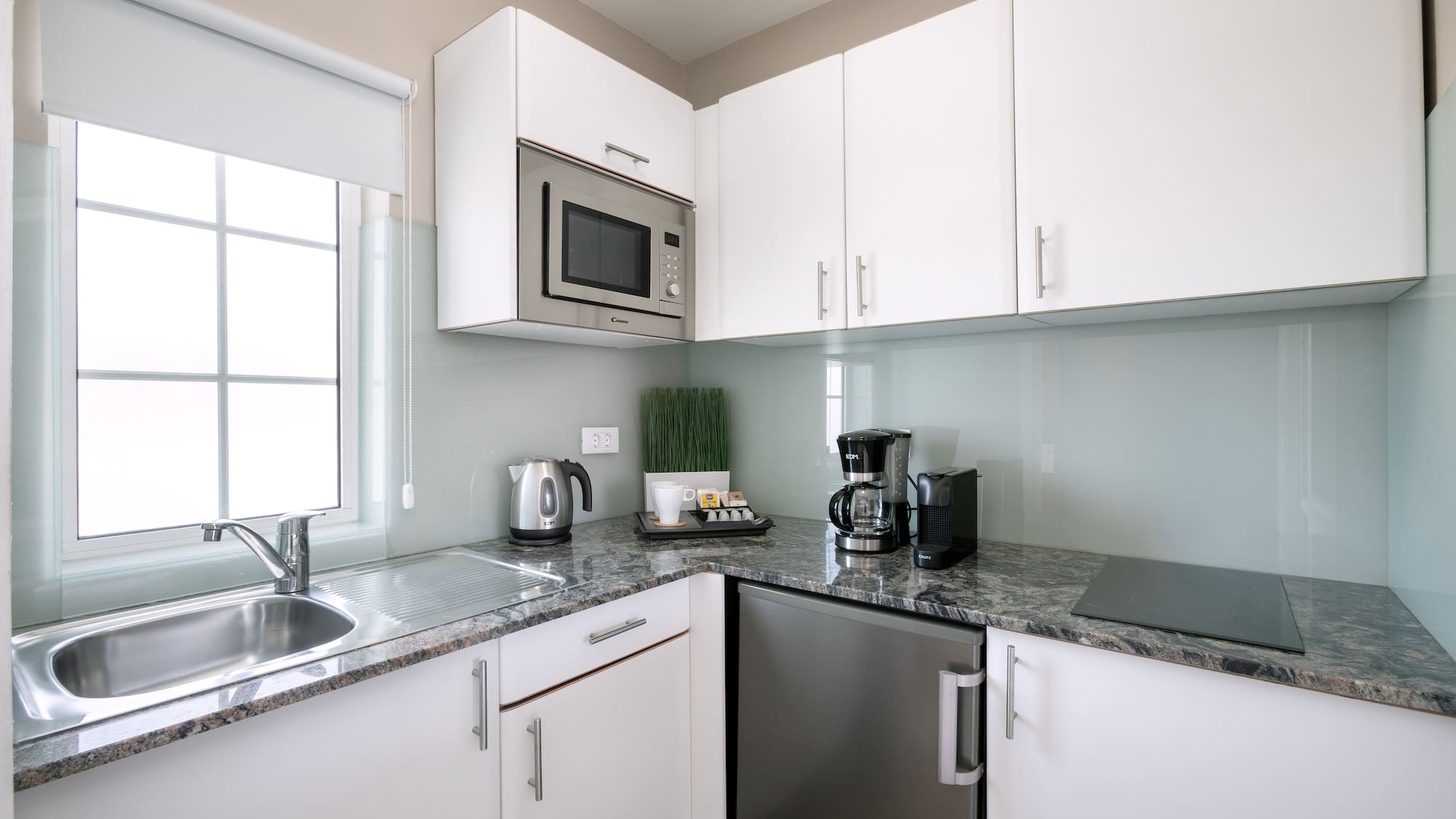 a kitchen with white cabinets and appliances