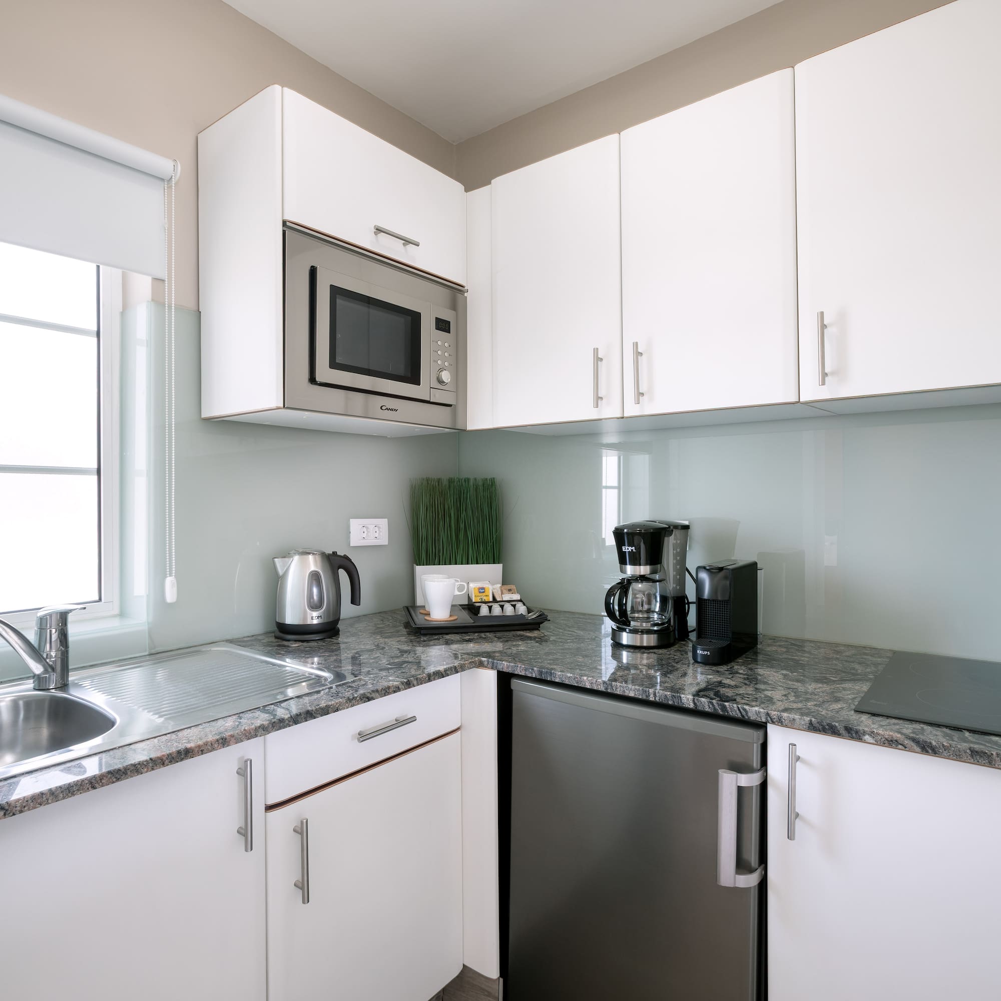 a kitchen with white cabinets and appliances