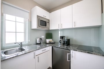 a kitchen with white cabinets and appliances
