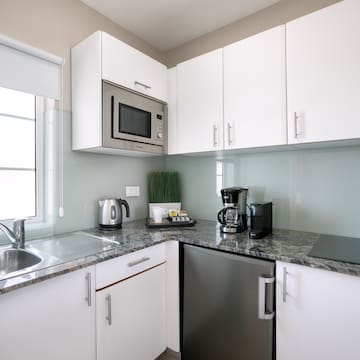 a kitchen with white cabinets and appliances
