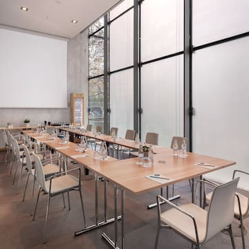 a long conference table with chairs and a projector screen