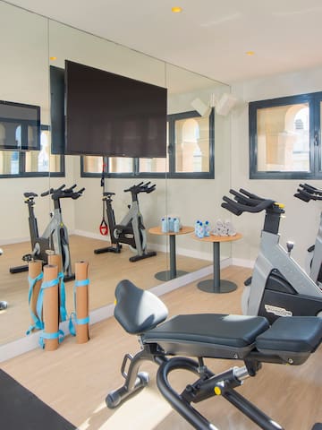 a room with exercise bikes and a mirror