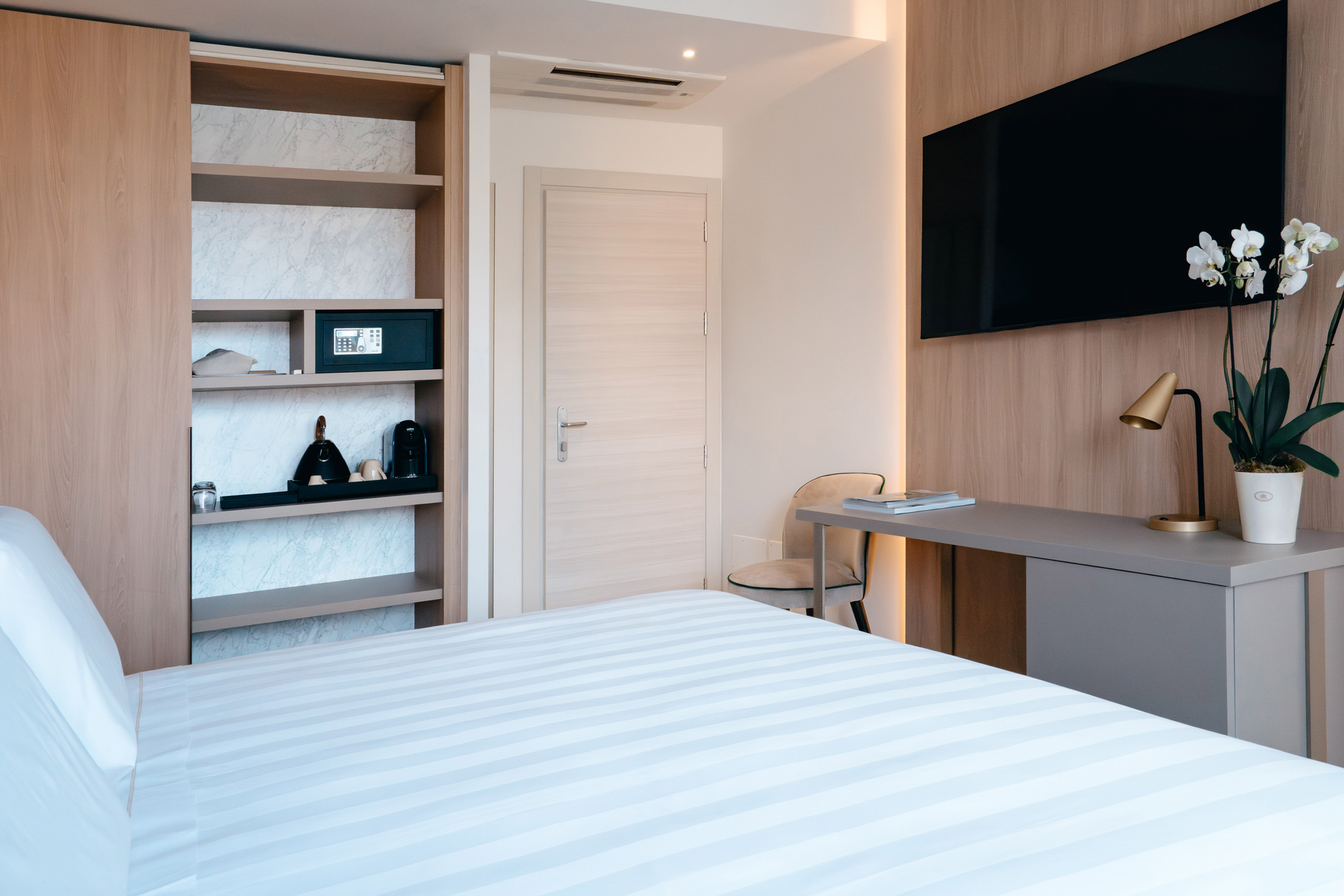 a room with a bed and a desk and a tv