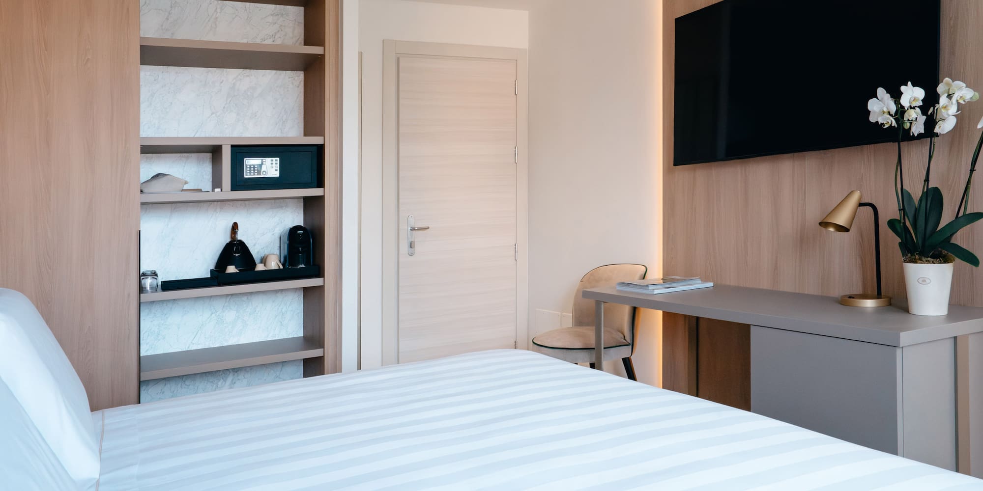 a room with a bed and a desk and a tv