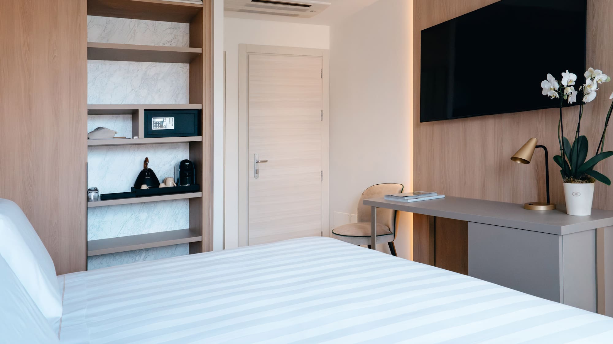 a room with a bed and a desk and a tv