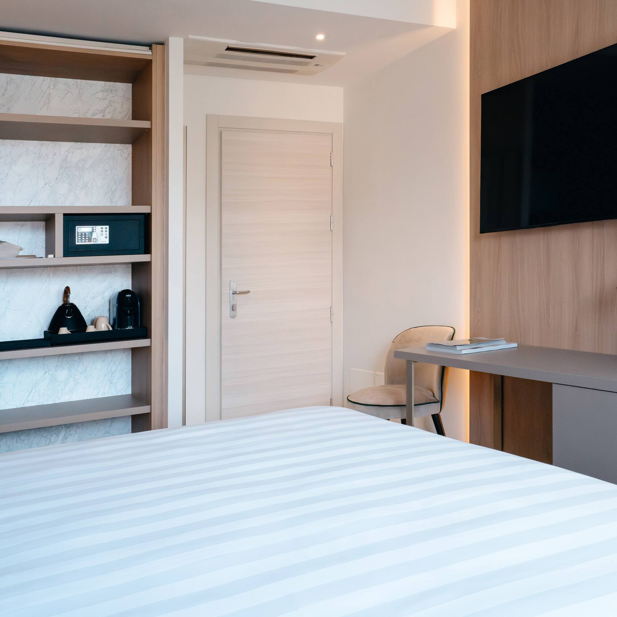 a room with a bed and a desk and a tv