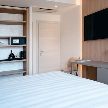 a room with a bed and a desk and a tv