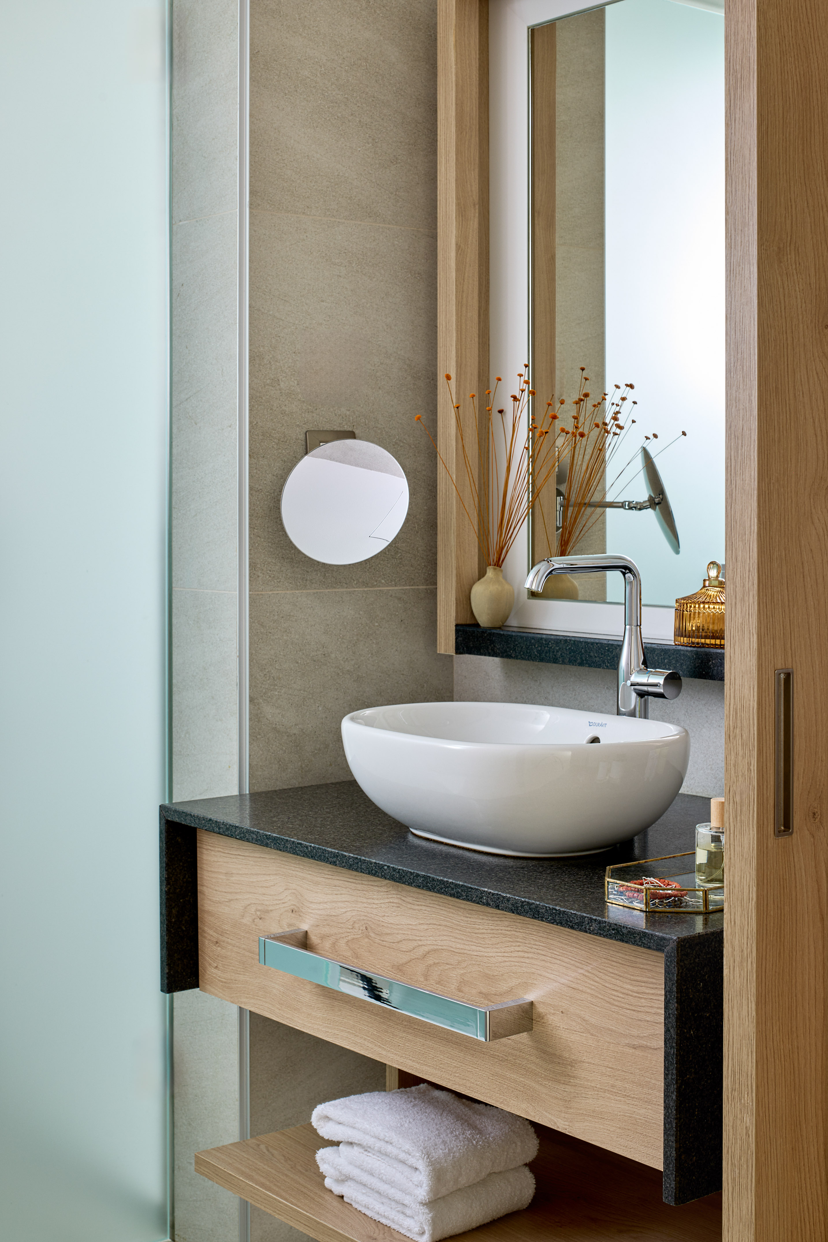 Modern bathroom vanity with white sink, chrome faucet, granite, wood cabinet, mirror.