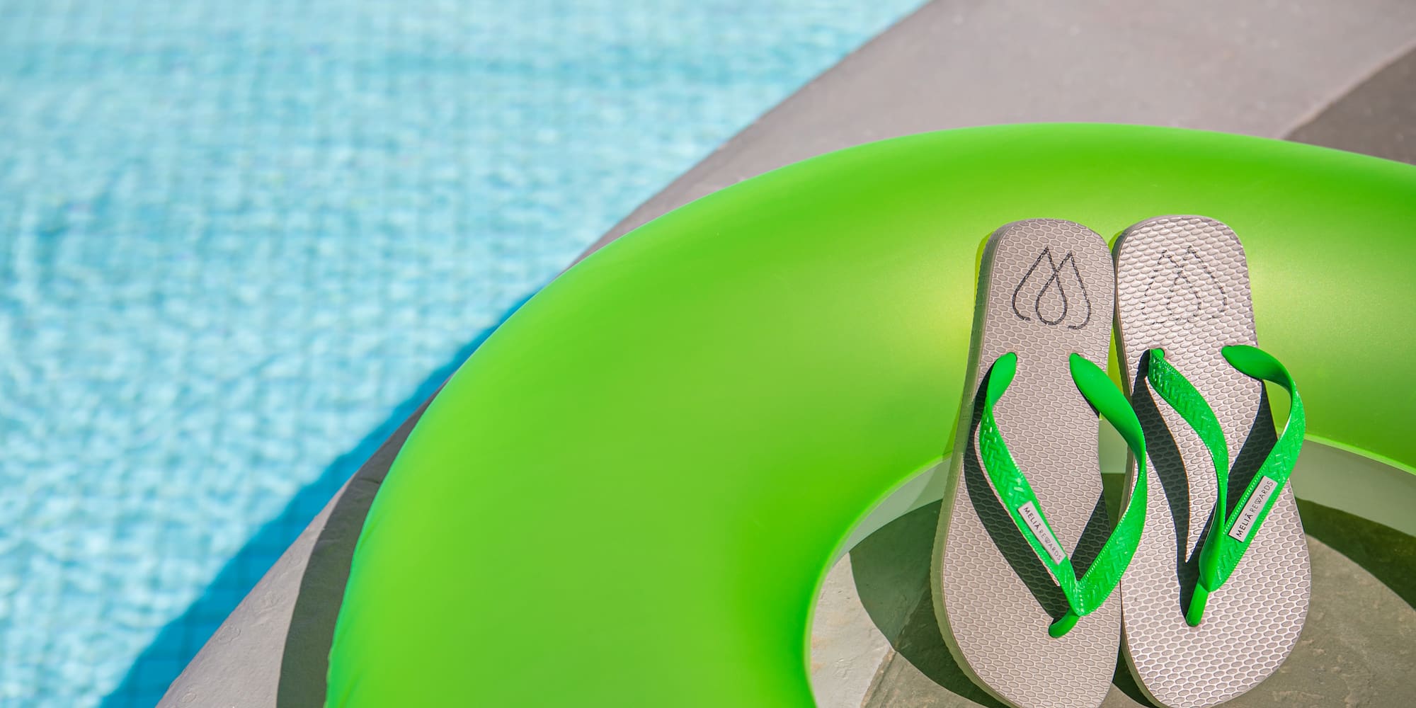 flip flops on a green float by a pool