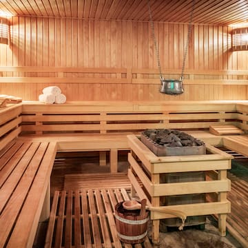 a sauna with wood walls and a bucket of charcoal