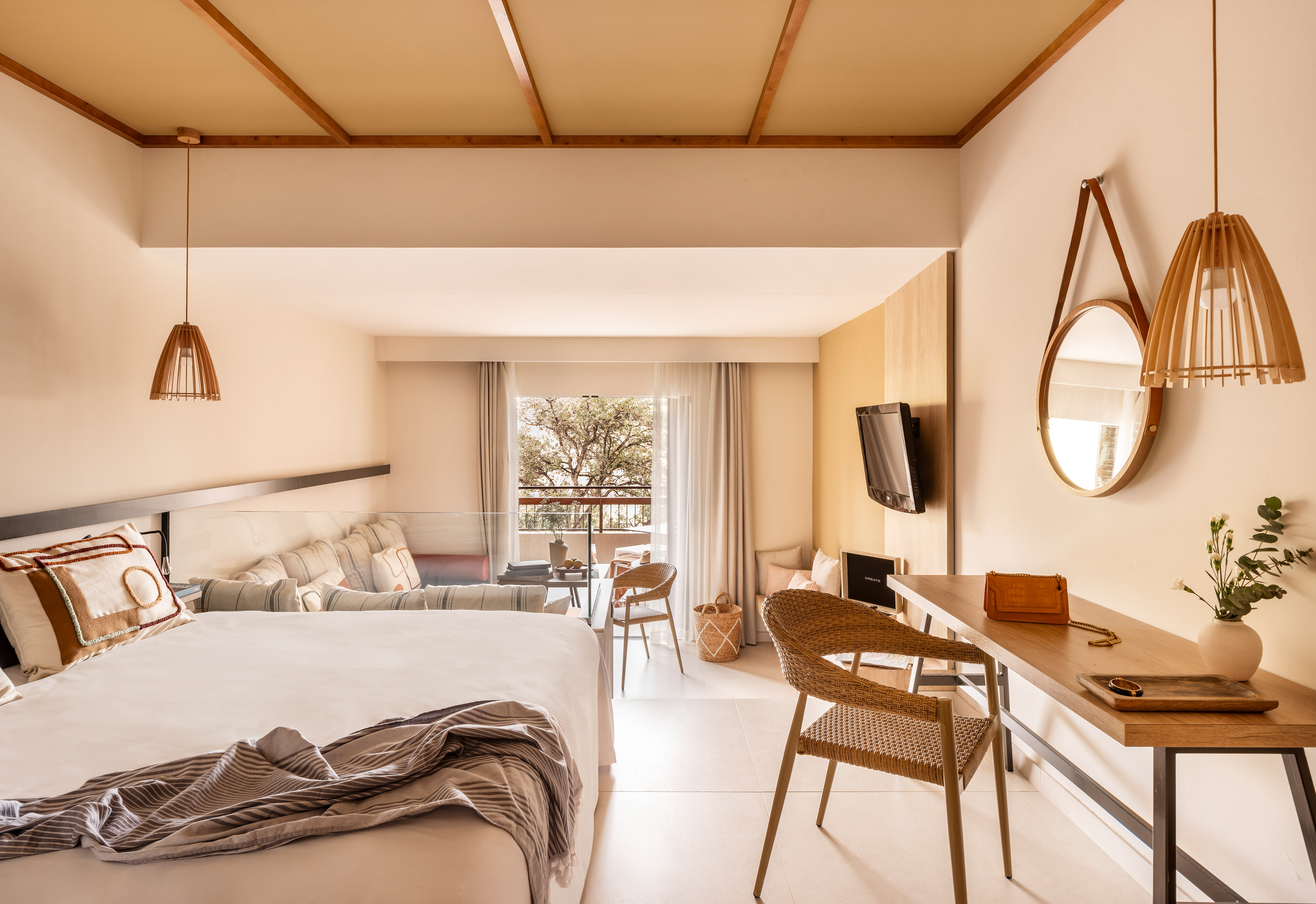 Contemporary hotel room with bed, wooden desk, natural decor, and balcony.
