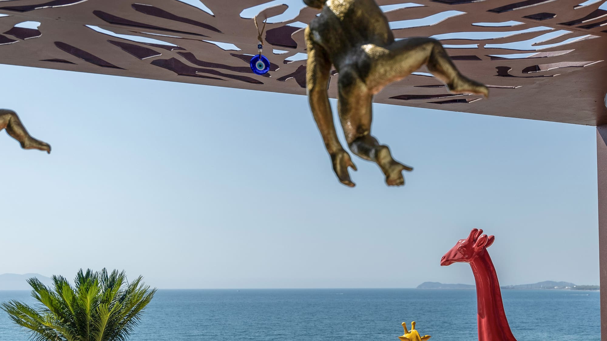 a statue of a monkey from a roof over a beach