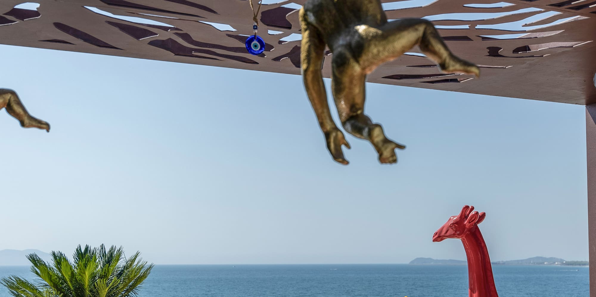 a statue of a monkey from a roof over a beach