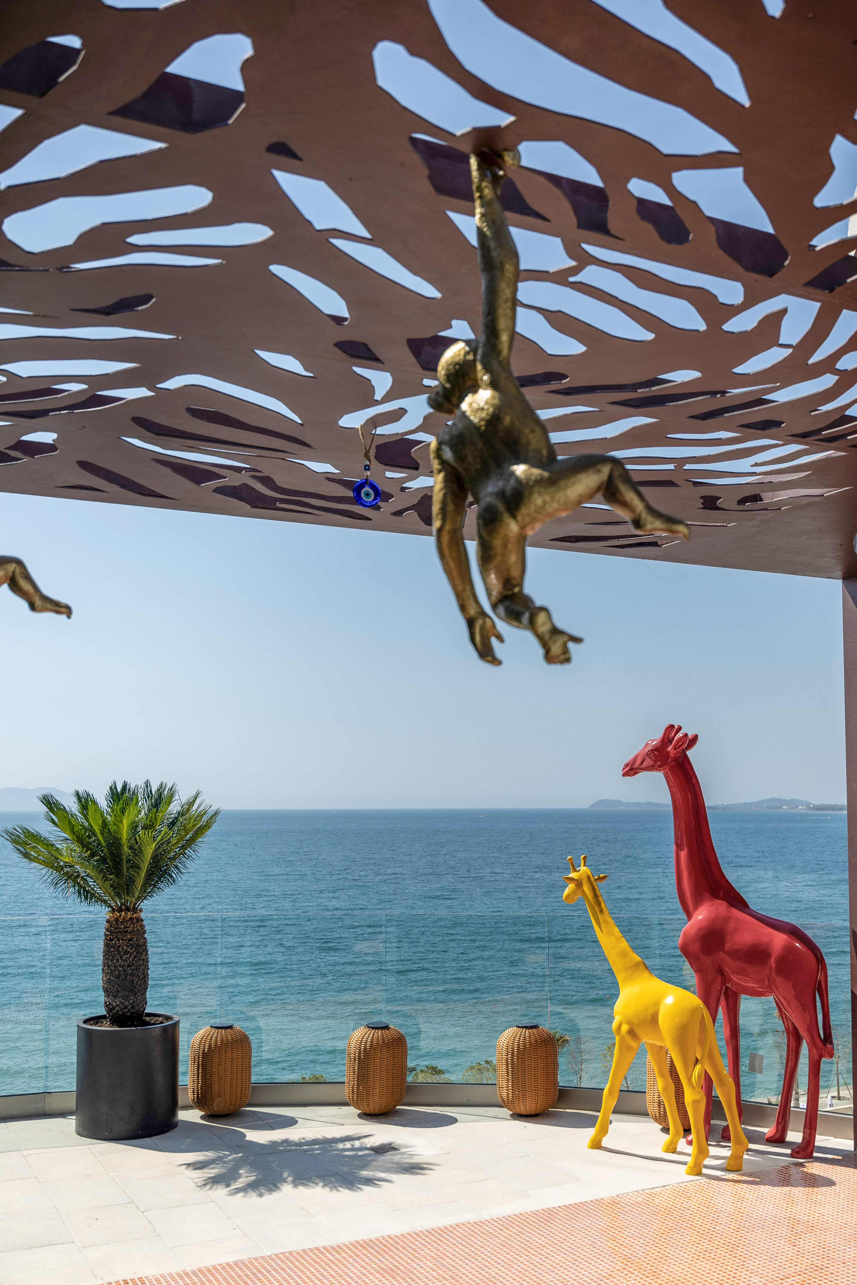 Golden monkey art, red and yellow giraffe statues, ocean view patio. - Savana Lounge, Aperitieven - Hotel Vlora Priam Affiliated by Meliá, Vlora