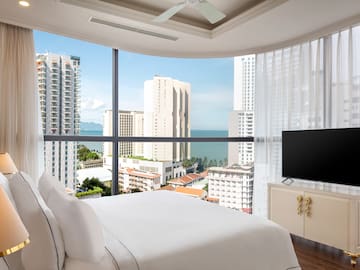 a bedroom with a television and a city view