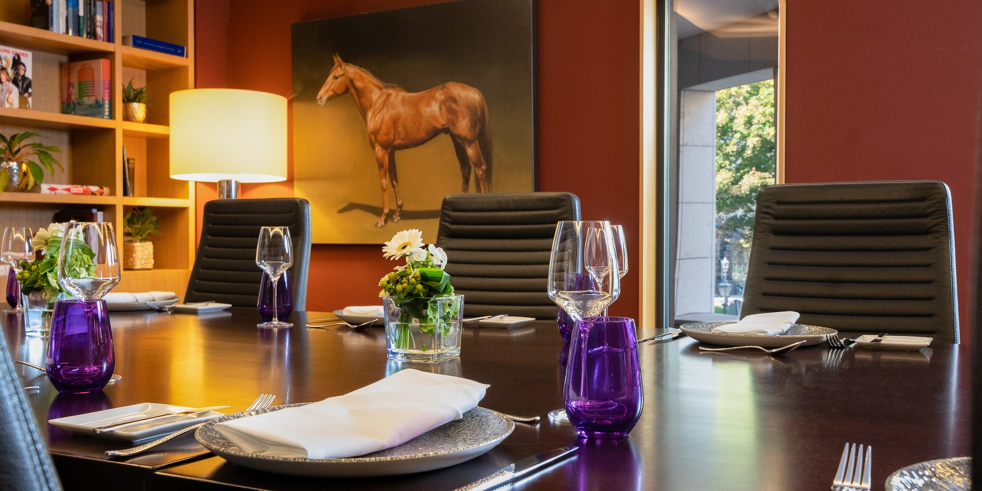 a table with chairs and a painting of a horse