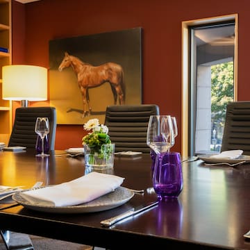 a table with chairs and a painting of a horse