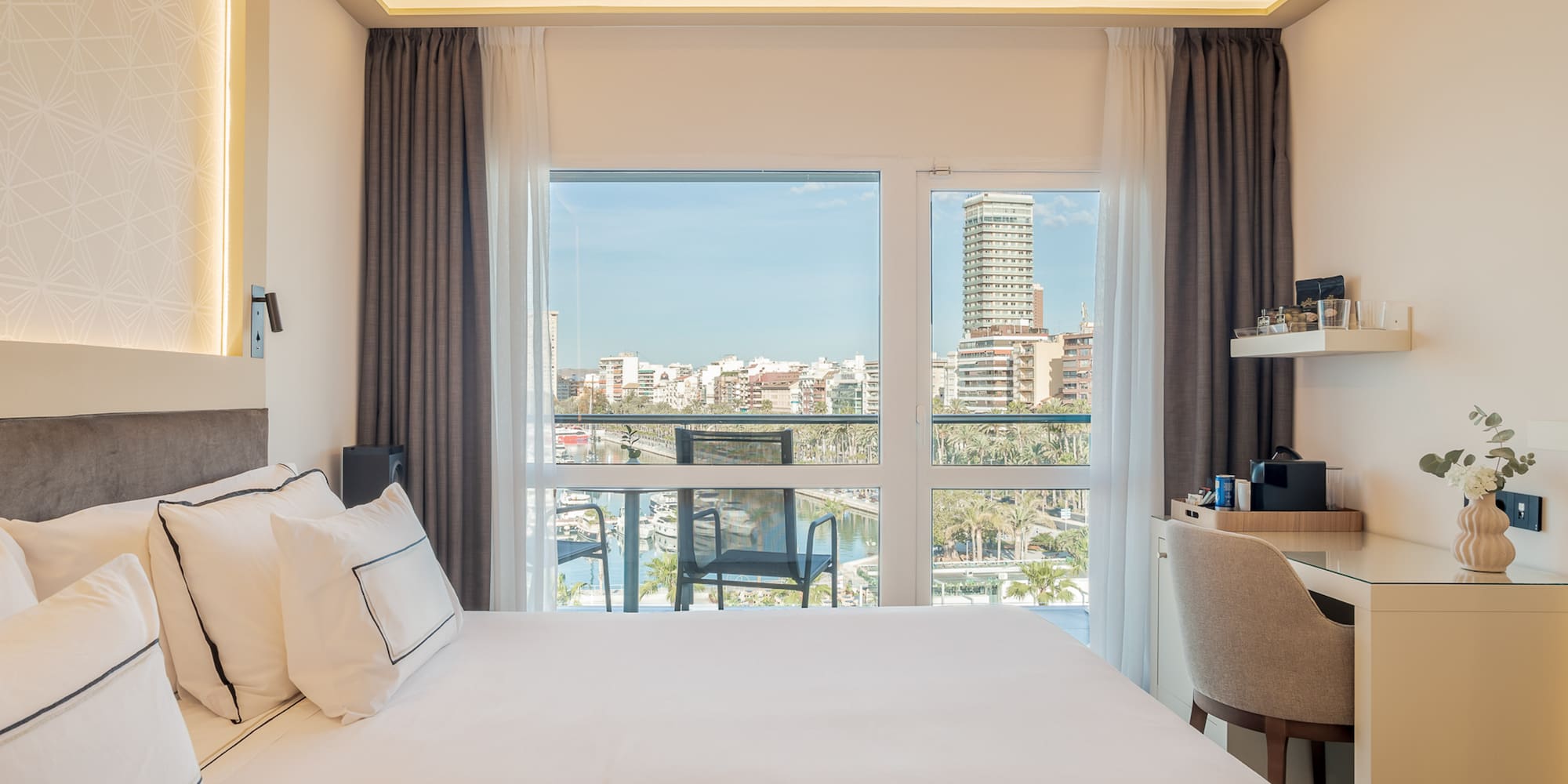 a bedroom with a large window and a city view