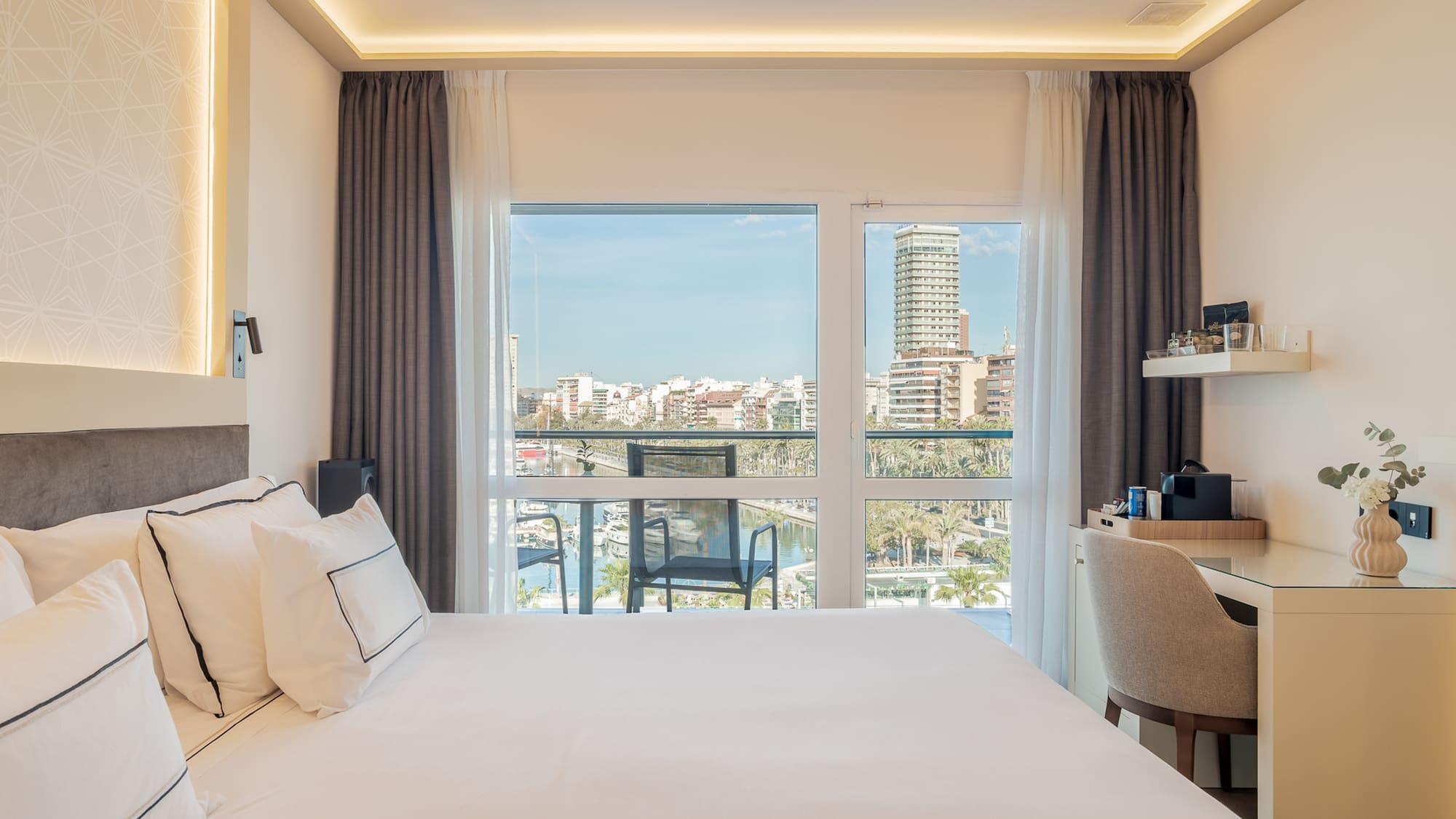 a bedroom with a large window and a city view