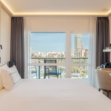 a bedroom with a large window and a city view