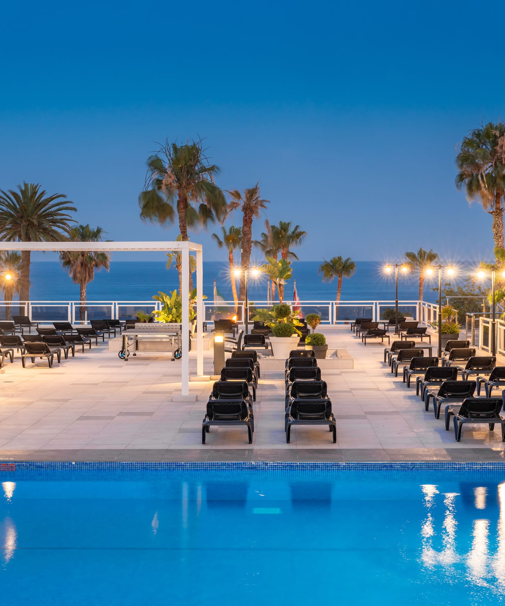 a pool with chairs and palm trees