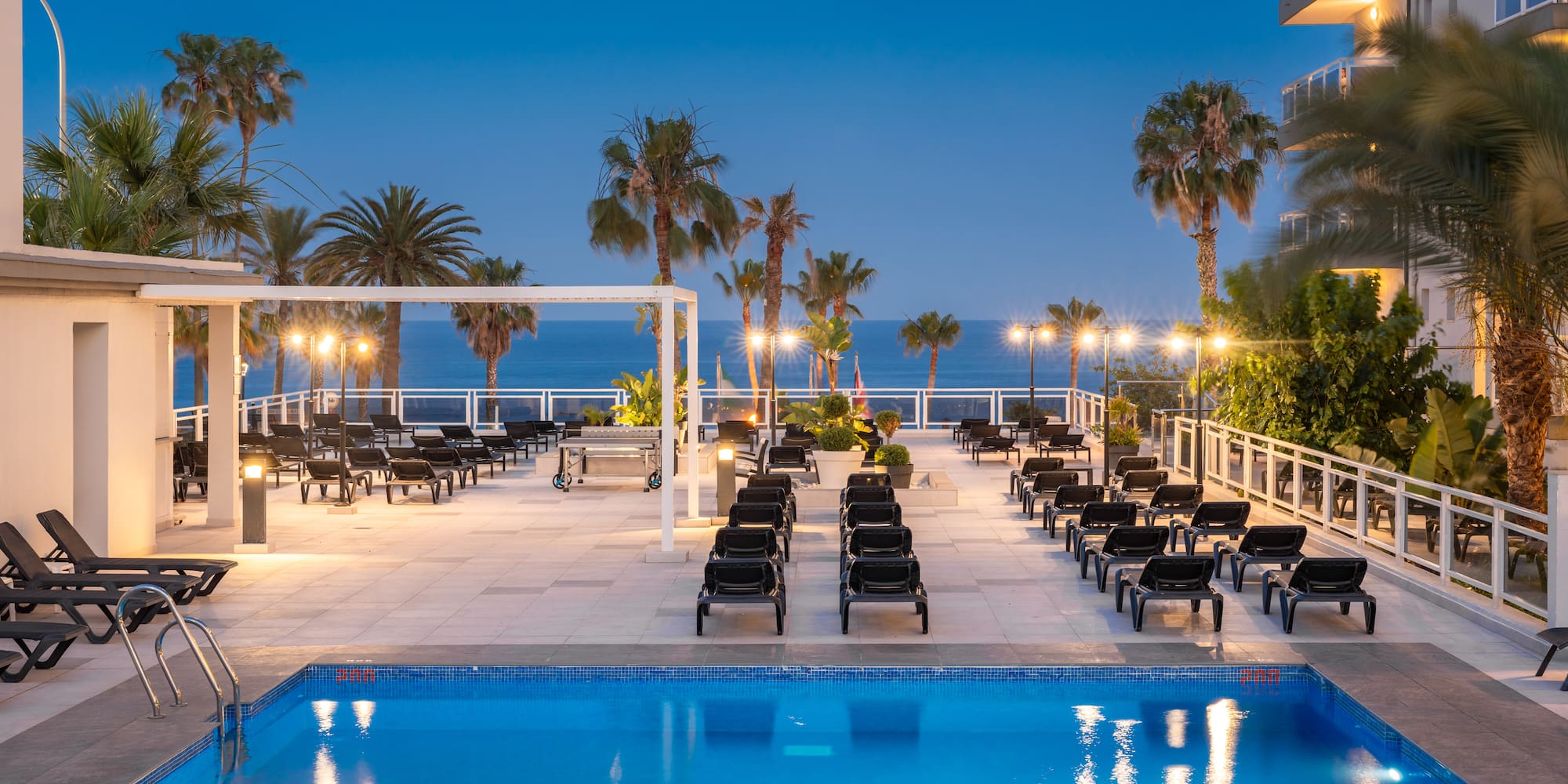a pool with chairs and palm trees