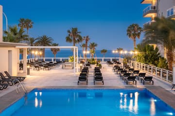a pool with chairs and palm trees