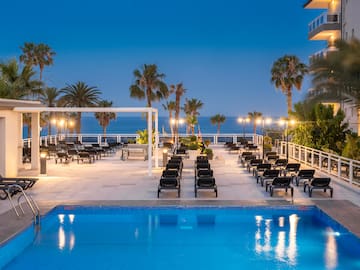 a pool with chairs and palm trees